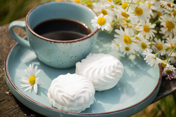 coffee and marshmallow with a bouquet of daisies. summer still life