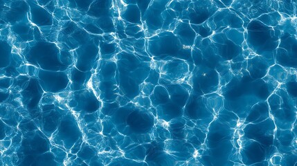 Top view of blue water texture with light reflections, resembling a swimming pool surface