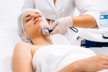 Modern beauty salon: a cosmetologist performs advanced RF-lifting for facial tightening and rejuvenation. Perfect for showcasing cutting-edge anti-aging treatments and aesthetic procedures.