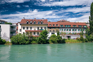 Fototapeta premium Beautiful riverfront buildings along the Aare in Bern, Switzerland, showcasing stunning architecture on a sunny day