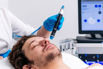 Man in a cosmetic clinic undergoing facial cleansing and rejuvenation treatments. Premium skincare technologies for radiant, refreshed skin. Perfect for promoting salon services and advanced skincare.