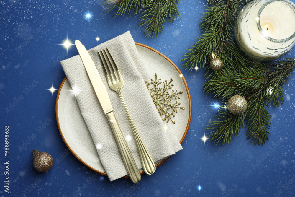 Poster beautiful christmas setting with plate, elegant cutlery and festive decor on blue table, flat lay. b