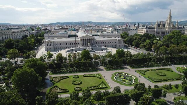 The austrian parliament surrounded by gardens and cityscape in vienna, aerial view