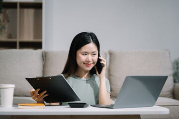 Happy woman speaking to mobile phone at home. women speak with remote clients using phone. sitting on sofa