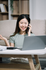 Happy woman speaking to mobile phone at home. women speak with remote clients using phone. sitting on sofa