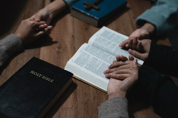 Closeup of simple wooden Christian cross on Bible. Concept of hope, faith, christianity, religion.