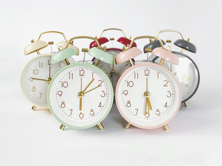 horizontal photo of round classic several colorful table alarm clocks on white background, copyspace