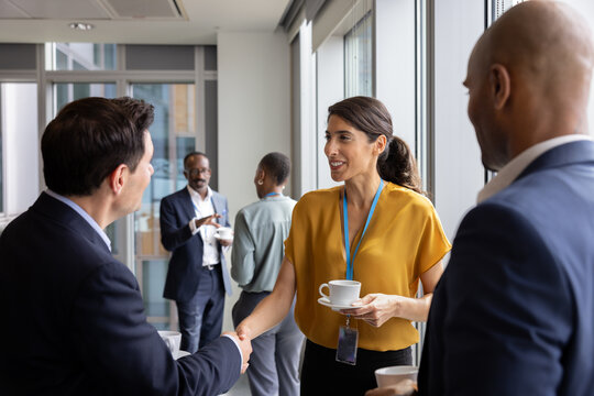 Handshake at a corporate business conference between a businessman and businesswoman