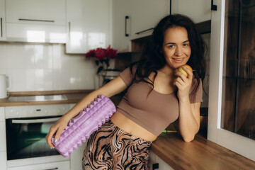 woman in the kitchen with a yoga roller