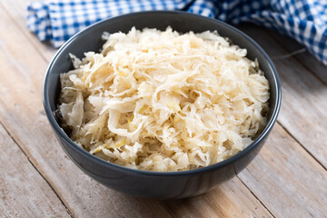 Sauerkraut in a bowl on wooden table. Traditional german food