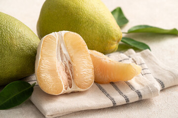 Fresh pomelo fruit with leaf on white table background.