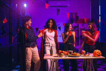 Asian friends, middle-aged man and young woman, enjoy Halloween office party with vampire costumes,...