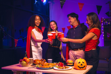 Asian friends, middle-aged man and young woman, enjoy Halloween office party with vampire costumes,...