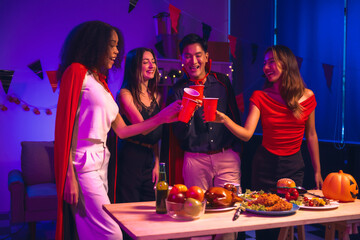 Asian friends, middle-aged man and young woman, enjoy Halloween office party with vampire costumes,...