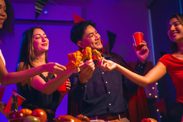 Asian friends, middle-aged man and young woman, enjoy Halloween office party with vampire costumes,...