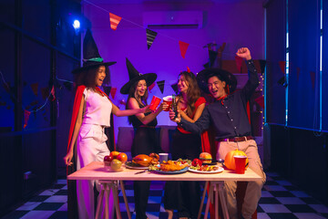 Asian friends, middle-aged man and young woman, enjoy Halloween office party with vampire costumes,...
