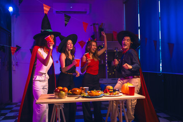 Asian friends, middle-aged man and young woman, enjoy Halloween office party with vampire costumes,...