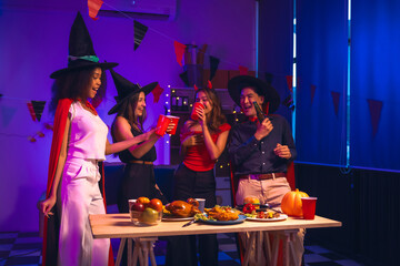 Asian friends, middle-aged man and young woman, enjoy Halloween office party with vampire costumes,...