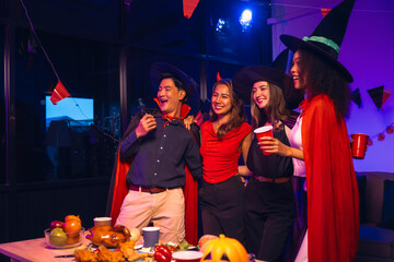 Asian friends, middle-aged man and young woman, enjoy Halloween office party with vampire costumes,...
