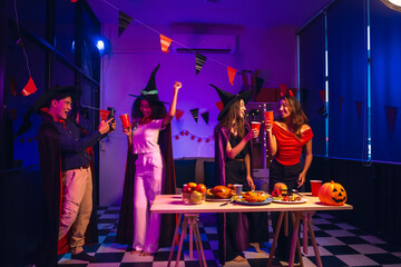 Asian friends, middle-aged man and young woman, enjoy Halloween office party with vampire costumes,...