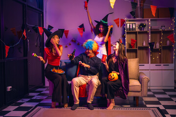 Asian friends, middle-aged man and young woman, enjoy Halloween office party with vampire costumes,...