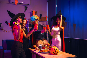 Asian friends, middle-aged man and young woman, enjoy Halloween office party with vampire costumes,...