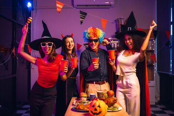 Asian friends, middle-aged man and young woman, enjoy Halloween office party with vampire costumes,...