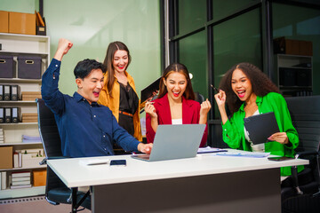 Obraz premium Asian colleagues, middle-aged man and young woman, happily collaborate in office workplace. They gather around laptop, discussing project management, startup plans, teamwork paper stacks on desk.