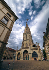 Fototapeta premium Exploring the stunning architecture of the Bern Cathedral under a dramatic sky in Bern, Switzerland