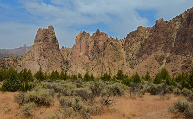 Fototapeta premium eroded volcanic rock formations and dramatic cliffs on a sunny summer day in the high desert of smith rock state park, near bend, in central oregon