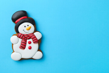 Tasty Christmas cookie in shape of snowman on light blue background, top view. Space for text