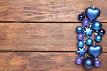 Christmas decor. Different baubles on wooden table, flat lay. Space for text