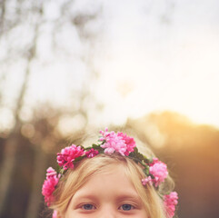 Naklejka premium Child, flower crown and eyes for fun, playful space and peekaboo games outside nature. Girl, kid and youth in hide and seek activity, backyard dress up and fairy princess costume for birthday