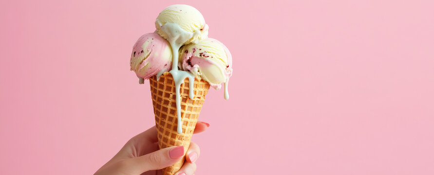 Female hand holding a waffle cone with ice cream scoops, ice cream melting and flowing down her hand. Pastel background, copy space