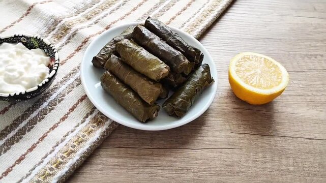 Delicious oriental Turkish dolma made of grape leaves stuffed with rice on a decorative plate
