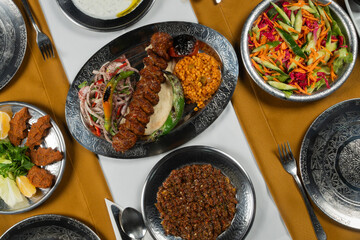 Top view, traditional Turkish cuisine and table setting, adana kebab, food service, appetizers and dishes.