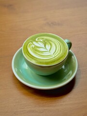 A cup of Japanese matcha latte. The beautiful latte art of hot  greentea with milk in cafe.