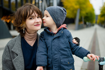 Fototapeta premium Teenage sister and her little brother having fun outdoors. Young girls with a toddler boy on autumn day.