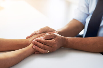 Holding hands, psychologist and patient for comfort, talking or communication for bad news, diagnosis or support. Doctor, medical discussion or empathy together for care, help or wellness in hospital