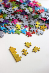 Colorful jigsaw puzzle pieces, cup of tea or coffee, eyeglasses and fresh berries for snacking. Hygge at home. Selective focus.