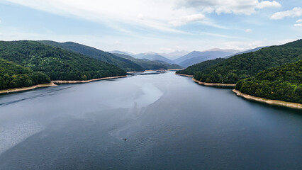 Carpathian mountains with Vidraru dam and lake. Top cinematic aerial view. Romania, Transfagaras road. The most famous and beautiful road in the Europe - Powered by Adobe