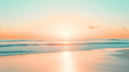 Fototapeta premium Bright orange sunset over a pale blue sky reflecting on a serene beach with gentle waves lapping at the shore