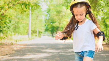 Girl skateboard with safety equipment - helmet, knee and elbow pads. Safe summer activity. Kids activity.