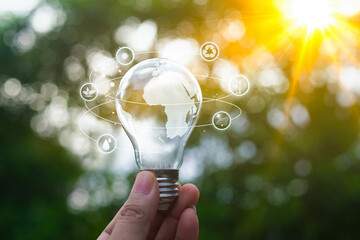 Hand holding a light bulb with icons design to renewable energy. creative ideas for save...