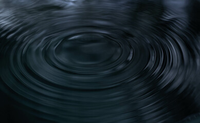 Ripple of water or water drop splash on black background. Abstract shape out of the water
