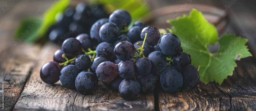 Aufkleber a cluster of fresh black grapes on a wooden table is in selective focus. with copy space image. plac