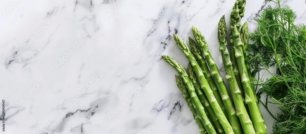 Poster fresh asparagus in a glass on a marble background with copy space