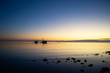 a sunken ship on a beach at sunset
