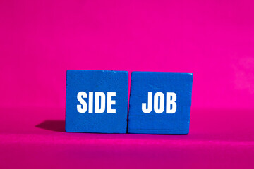 Side job message written on blue wooden cubes on pink background. Conceptual side job symbol. Copy space.