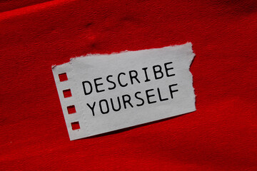 Describe yourself message written on ripped torn paper piece on red background. Conceptual describe...